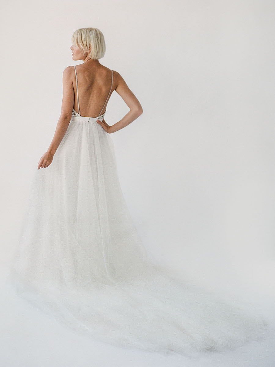 Comfortable champagne-toned wedding dress with white beading, an open back, and a soft princess tulle skirt