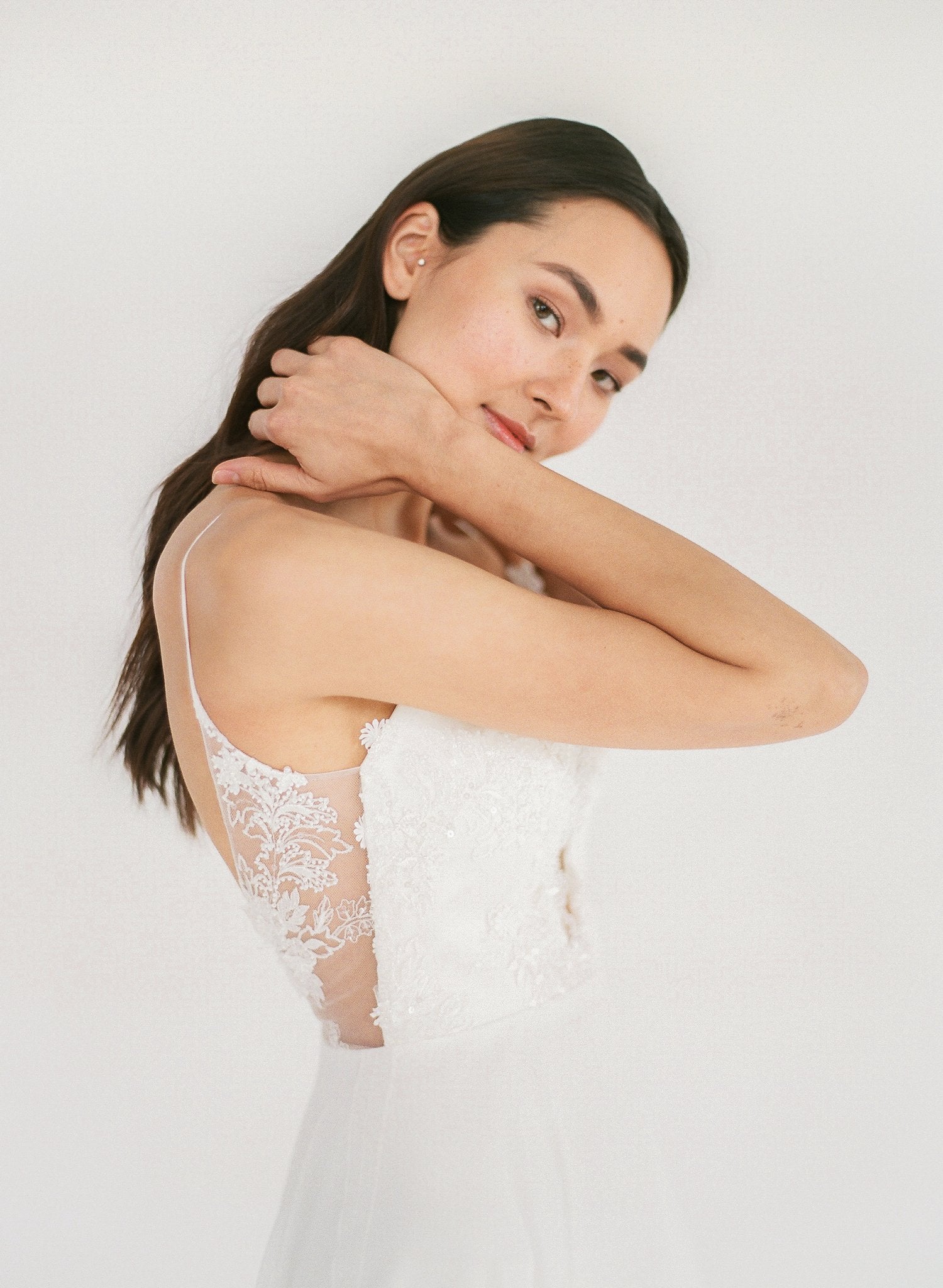 Ethically made flowy beach wedding dress with lace appliqué, a low back, and plunging neckline