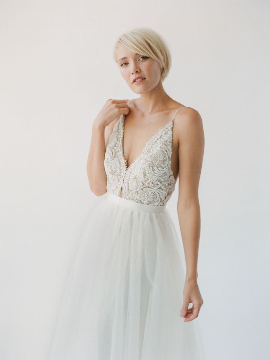 Comfortable champagne-toned wedding dress with white beading, an open back, and a soft princess tulle skirt